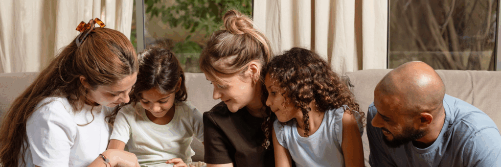 משפחה יושבת בסלון ומשחקת בחשבוניה